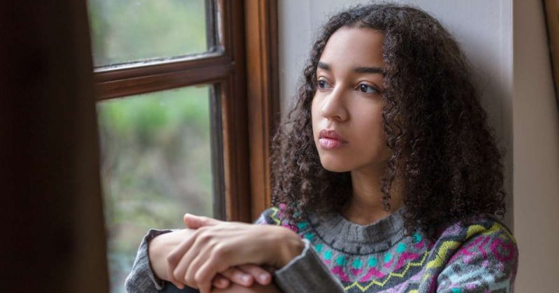 safe house project thoughtful young girl looks out a window